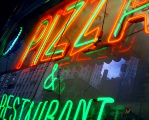 Close-up of neon sign for pizza and restaurant.